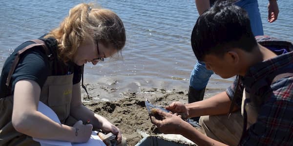 Teacher and student measuring clams