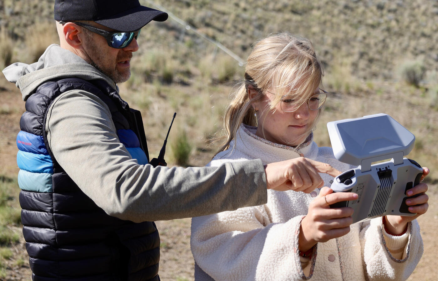 Andrea flies a drone with instructor help.