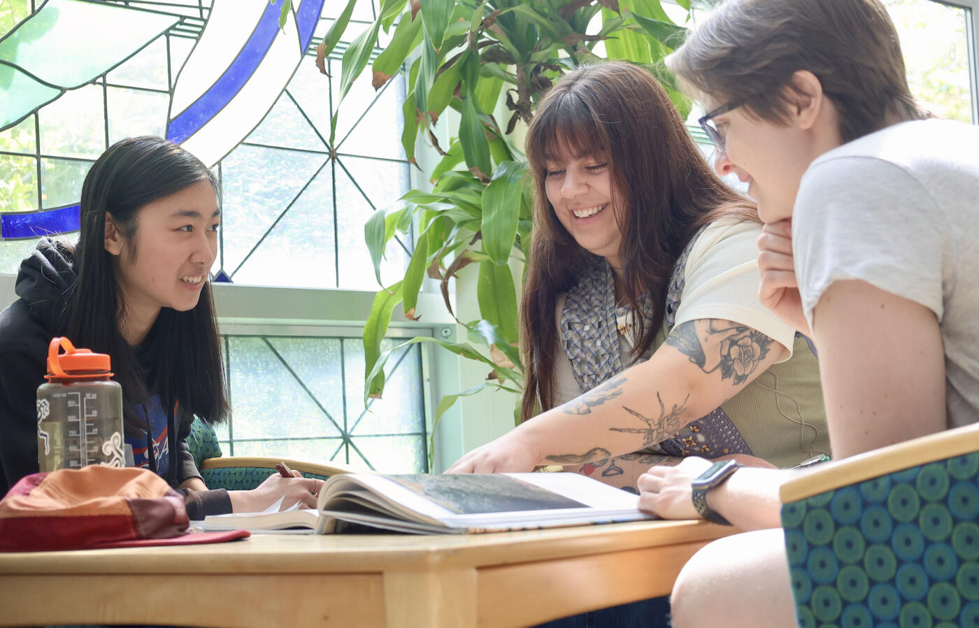 Heather smiles with friends in the Burt atrium (Heather on right wearing NASA sweatshirt).