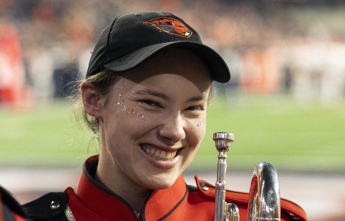 Brooke smiles wearing her OSU marching band uniform on the field during a game.