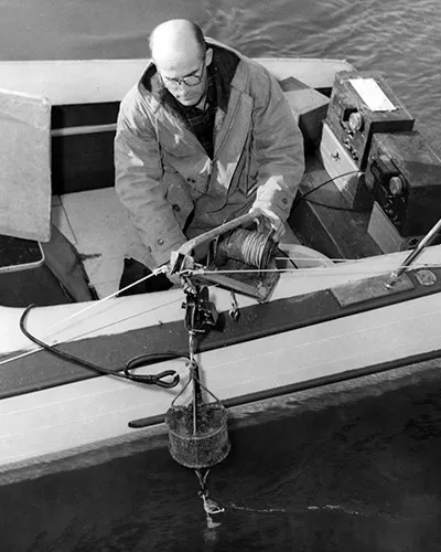 Wayne Burt deploying an instrument from a small boat