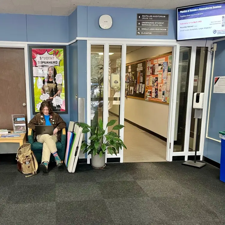 student sitting in a chair in the Wilkinson Hall lobby