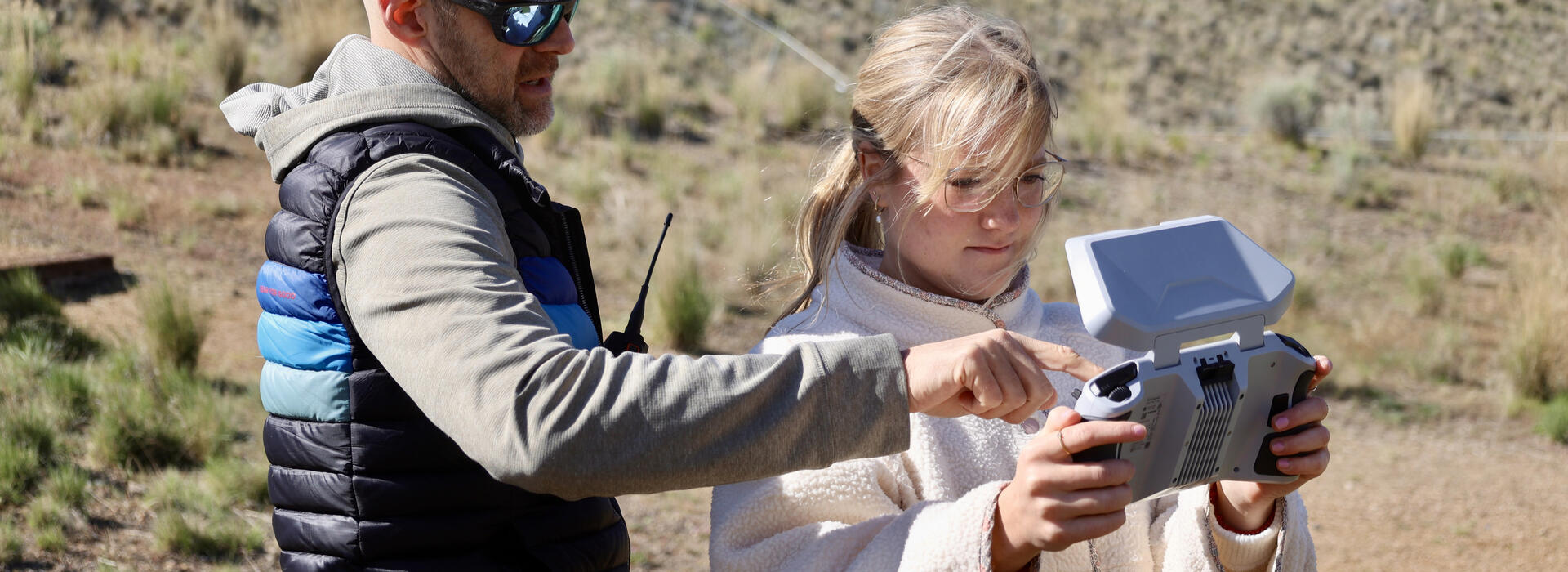 Andrea flies a drone with instructor help.