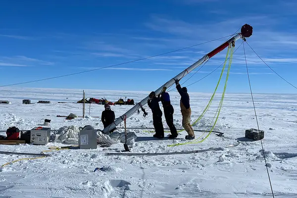 Four researchers setting up an ice drill